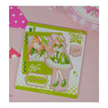 Acrylic stand parts on the printed sheet: Sumika Shiun figure in a green lolita dress, base and signature plate