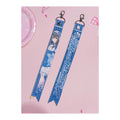 Front and back of the Temari Tsukimura ribbon keychain: illustration with signature, and the name Temari Tsukimura