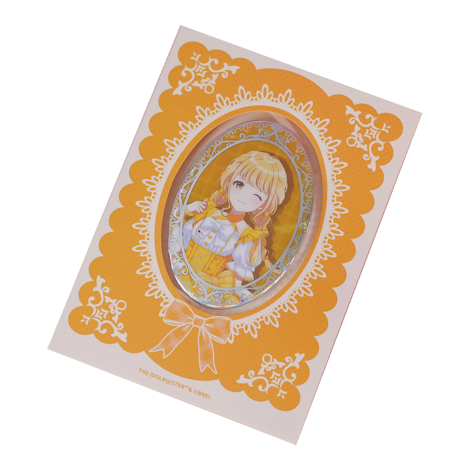 Kotone Fujita oval holographic badge on its yellow lace-patterned backing card.