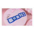 Name keychain: blue plate reading "秦谷美铃担当" in white, with a clasp and a small clear charm