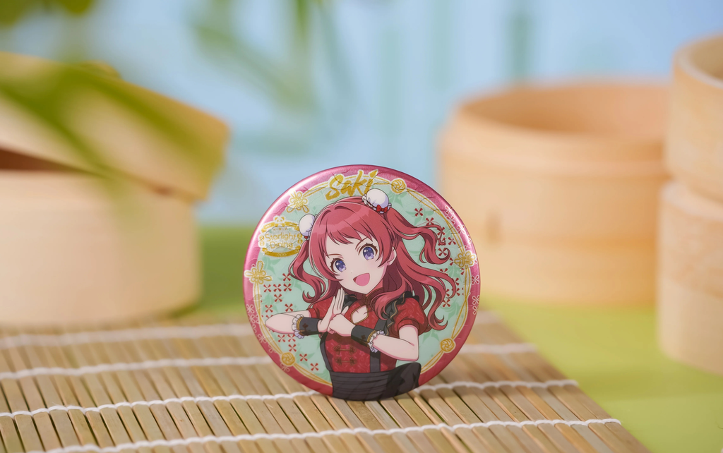 花海咲季の絵柄：拱手のポーズをとる咲季のピンク縁の缶バッジ