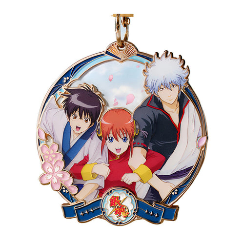 Round Yorozuya medal with Shinpachi, Kagura and Gintoki, cherry blossoms, a blue ribbon and a gold-tone ring on top
