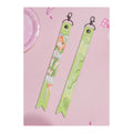 Front and back of the Sumika Shiun ribbon keychain: illustration with signature, and the name Sumika Shiun