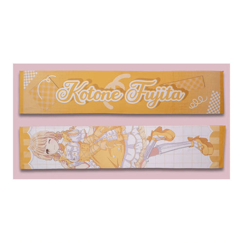 Both sides of the Kotone Fujita muffler towel: yellow name side and full-length lolita-outfit illustration