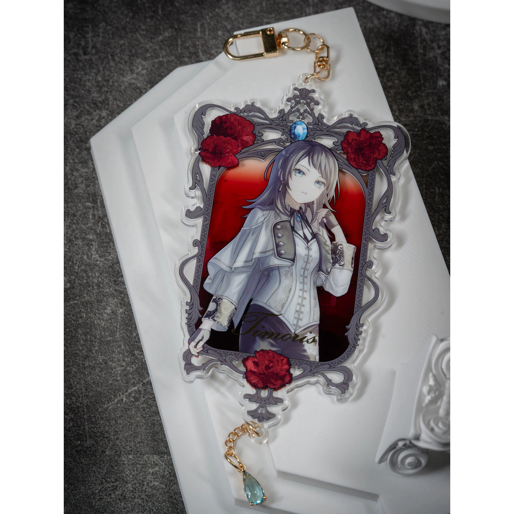 Front of the Timoris acrylic keychain: ornate frame with red flowers, gold-tone clasp and a light blue teardrop charm