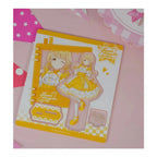 Acrylic stand parts on the printed sheet: Kotone Fujita figure in a yellow lolita dress, base and signature plate