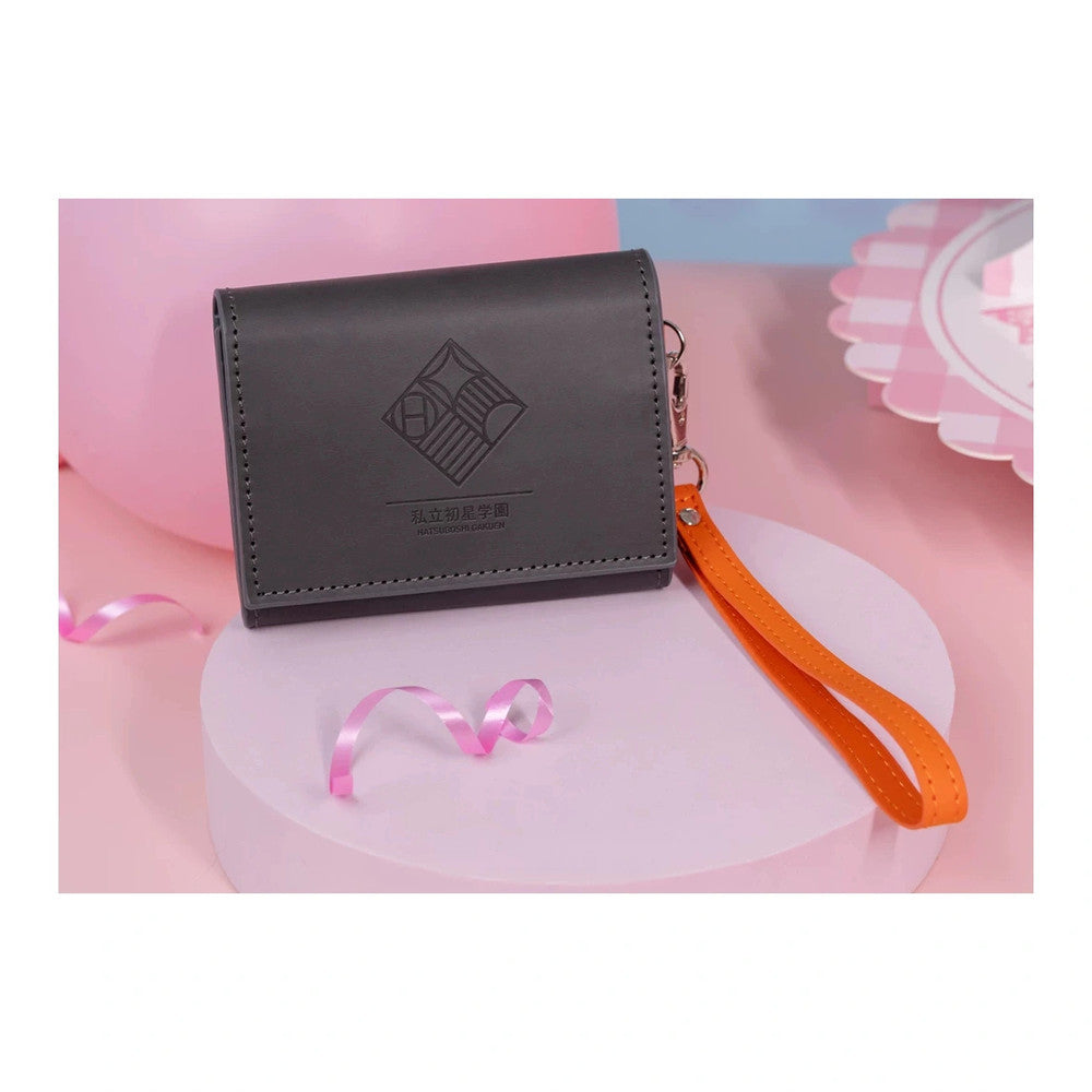 Black flap card case pressed with the Hatsuboshi Gakuen crest, with an orange wrist strap (props not included)