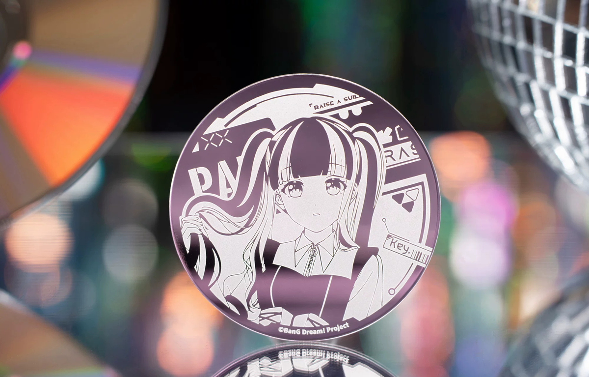 The PAREO badge standing in front of a CD and a mirror ball (props not included)