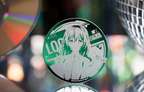 The LOCK badge standing in front of a CD and a mirror ball (props not included)