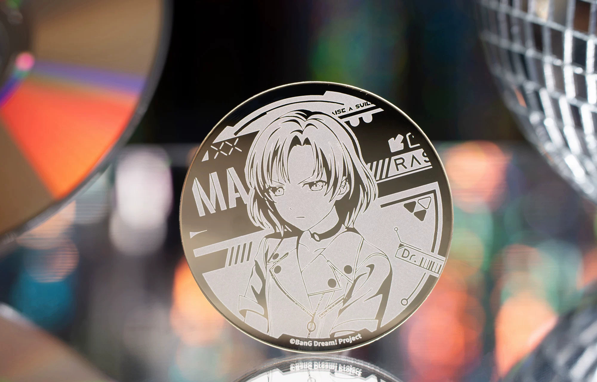 The MASKING badge standing in front of a CD and a mirror ball (props not included)